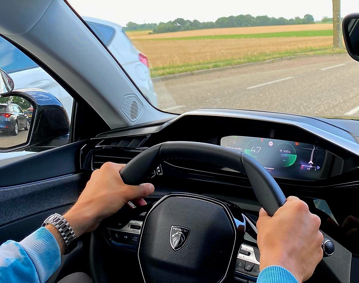 Twee handen vast aan het stuur tijdens het rijden, bewuste controle