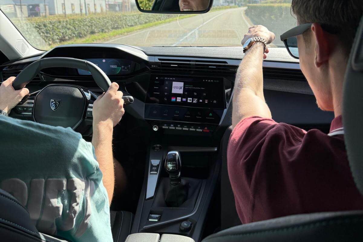 Thijs geeft rijles, instructeur en leerling samen in de lesauto tijdens het schakelen